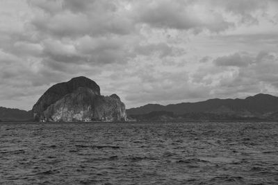 Rock formation in sea against sky