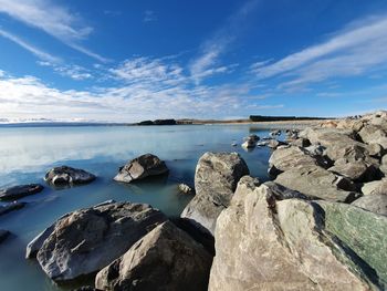 Scenic view of rocks in sea against sky