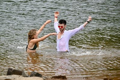 Rear view of two people enjoying in water