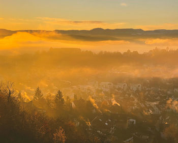 Foggy valley  view from the top of the mountain against sky during sunset