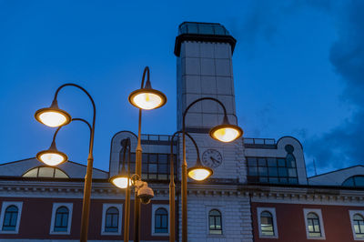 Low angle view of illuminated street light against building at night