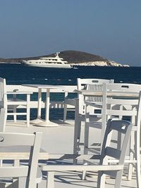 Chairs on beach against clear sky