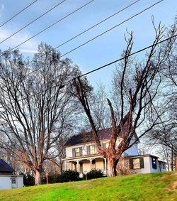 Built structure with bare trees in foreground