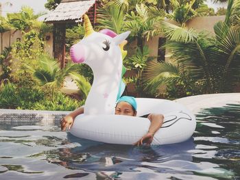 Portrait of woman with inflatable ring swimming in pool