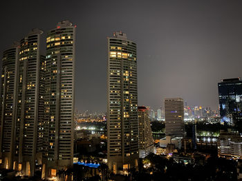 Illuminated buildings in city against sky at night