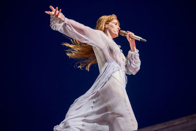 Low angle view of woman dancing against sky