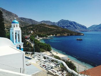 High angle view of buildings by sea against blue sky