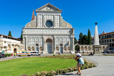 People in front of historic building against sky