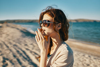 Portrait of young woman wearing sunglasses on beach