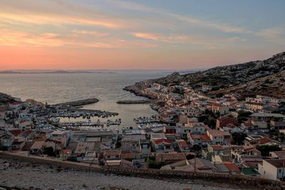 High angle view of townscape by sea against sky during sunset