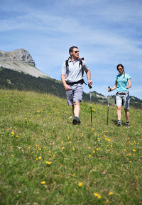 Full length of boys on grassy field against sky