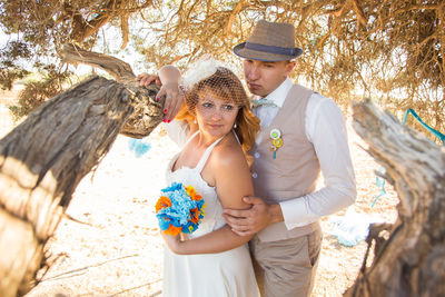 Couple embracing by tree on beach