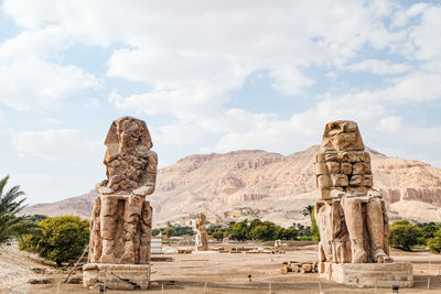 Giant statues against cloudy sky. luxor, egypt.
