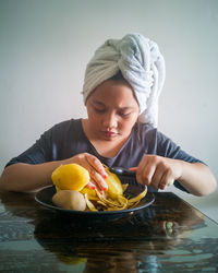 A young girl is peeling the potatoes. preparing cooking ingredients at home.