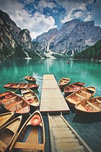 Boats moored on lake against mountains