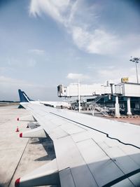 Airplane flying over airport runway against sky