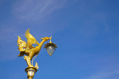 Low angle view of statue against blue sky