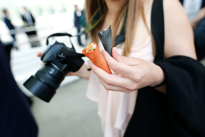 Midsection of woman holding mobile phone