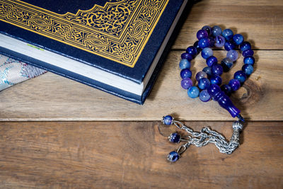 High angle view of book and necklace on table