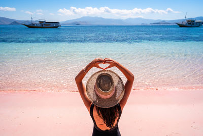 Rear view of woman sitting at beach