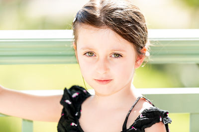 Portrait of girl standing against railing