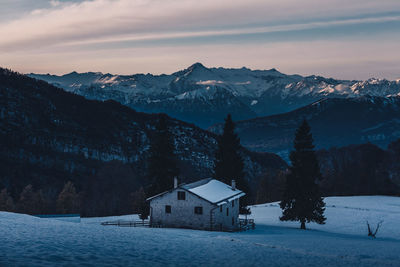 Houses on snowcapped mountain against sky