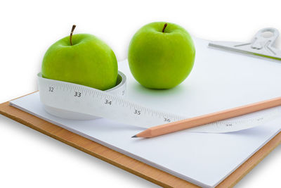 Close-up of fruits and vegetables on table against white background