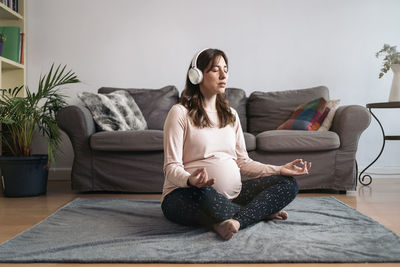 Young woman sitting on sofa at home