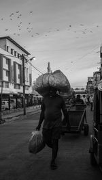 Man walking on street against sky