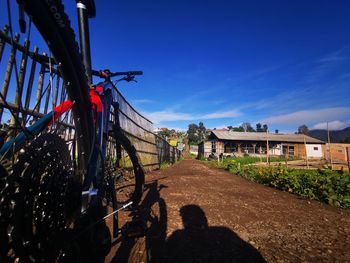 People on street amidst buildings against blue sky