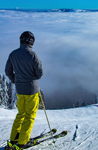 Full length of man standing on snowcapped mountain