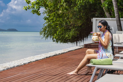 Beautiful woman drinking coconut juice at luxury resort in phuket