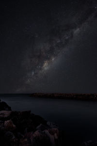 Scenic view of sea against star field at night