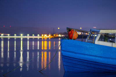 Illuminated bridge over sea against clear sky at night