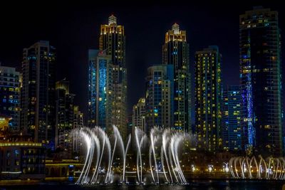 Panoramic view of illuminated buildings against sky at night