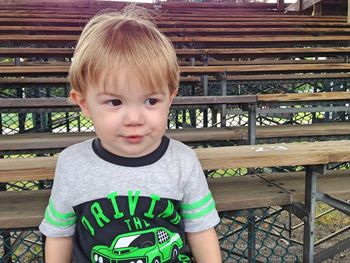 Boy sitting on bleacher at stadium