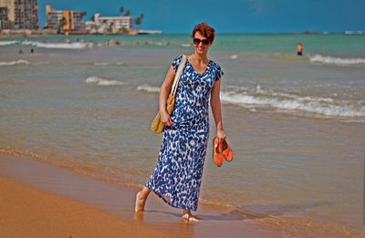 Full length of young woman standing on beach