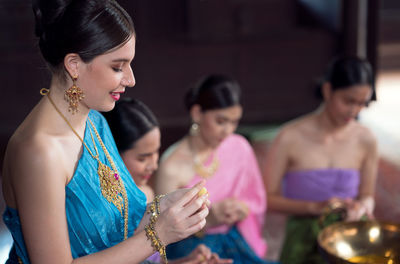 Thai women in ancient costumes in the ayutthaya period in an old house along with thai sweet food