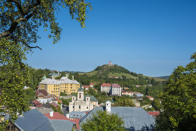 Buildings in town against clear blue sky