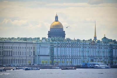 Buildings in city against cloudy sky