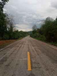 Road amidst trees against sky