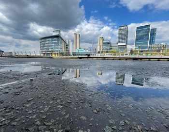 Reflection of building in puddle on city