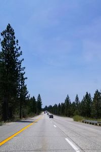 Road amidst trees against sky