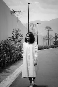 A young girl wearing a dress walking on the street towards the camera 