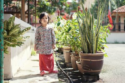 Woman standing by potted plants