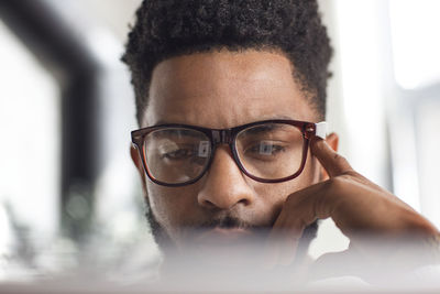 Close-up of concentrated man using laptop at home