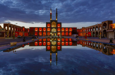 Reflection of building in puddle against sky