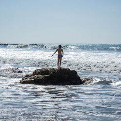 Full length of man standing on beach against clear sky