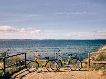 Scenic view of yellow bikes and the sea against the sky