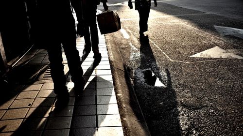 Low section of people walking on sidewalk